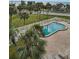 A kidney-shaped pool surrounded by brick pavers, lounge chairs, and lush greenery offers a relaxing outdoor space at 2530 Gary Cir # 401, Dunedin, FL 34698