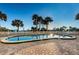 Inviting outdoor pool area surrounded by lush palm trees and lounge seating under a clear blue sky at 2530 Gary Cir # 401, Dunedin, FL 34698