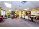 Bright recreation room featuring a treadmill, bookshelves, and multiple seating and table areas at 2530 Gary Cir # 401, Dunedin, FL 34698