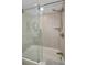Modern shower with glass door, stone tiling, and chrome fixtures and shower head at 2530 Gary Cir # 401, Dunedin, FL 34698