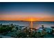 Sunset view of the ocean and a line of houses with palm trees in front of them at 2530 Gary Cir # 401, Dunedin, FL 34698