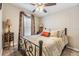 Bedroom with a metal bed frame, patterned bedding, bedside table, and decorative lamp at 3110 Moss Hill St, Wesley Chapel, FL 33543