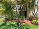 Condo building featuring a lush, green landscape and mature trees at 3300 Fox Chase N Cir # 229, Palm Harbor, FL 34683