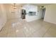 Bright living room with tile flooring and an open view into the modern kitchen with stainless steel appliances at 3300 Fox Chase N Cir # 229, Palm Harbor, FL 34683