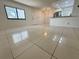 Bright living room with tile flooring and an open view into the modern kitchen with stainless steel appliances at 3300 Fox Chase N Cir # 229, Palm Harbor, FL 34683