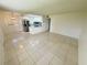 Bright living room with tile flooring and an open view into the modern kitchen with stainless steel appliances at 3300 Fox Chase N Cir # 229, Palm Harbor, FL 34683