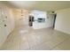 Bright living room with tile flooring and an open view into the modern kitchen with stainless steel appliances at 3300 Fox Chase N Cir # 229, Palm Harbor, FL 34683
