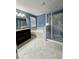Bright bathroom featuring a soaking tub, glass-enclosed shower, dark vanity with light granite at 3367 Janna Grace Way, Land O Lakes, FL 34638