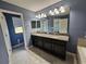 Bathroom featuring dual sinks, granite counters, and vanity mirrors at 3367 Janna Grace Way, Land O Lakes, FL 34638