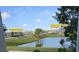 Picturesque view of the community featuring a pond, landscaped green space, and nearby amenities at 3367 Janna Grace Way, Land O Lakes, FL 34638