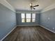 Spacious living room with wood flooring, ample natural light, and a modern ceiling fan at 3367 Janna Grace Way, Land O Lakes, FL 34638