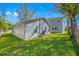 View of the back of the home showing the siding and the well-maintained lawn at 3709 W Dale Ave, Tampa, FL 33609