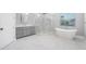 Bright bathroom featuring marble floors, a large walk-in shower, and a soaking tub at 3709 W Dale Ave, Tampa, FL 33609