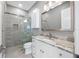 Bathroom with modern finishes, including a walk-in shower, granite countertops and white cabinets at 3709 W Dale Ave, Tampa, FL 33609