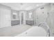A modern bathroom featuring dual vanities, a large shower, and a luxurious soaking tub at 3709 W Dale Ave, Tampa, FL 33609