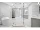 Modern bathroom with a glass enclosed shower, soaking tub, and gray cabinets at 3709 W Dale Ave, Tampa, FL 33609