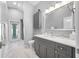 Bright bathroom with gray cabinets, a marble countertop, and a door to the outdoor patio at 3709 W Dale Ave, Tampa, FL 33609
