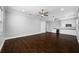 Spacious bonus room with dark wood floors, white cabinets, a sink, and two ceiling fans at 3709 W Dale Ave, Tampa, FL 33609