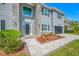 View of the home featuring interlocking pavers, manicured lawn, and stone facade entrance at 3709 W Dale Ave, Tampa, FL 33609