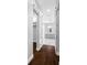Hallway with dark wood floors, grey walls, leading to bathroom with sliding barn door at 3709 W Dale Ave, Tampa, FL 33609