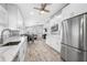 Modern kitchen featuring white cabinets, stainless steel appliances, and an open layout to the living area at 3709 W Dale Ave, Tampa, FL 33609