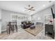 Cozy living room with a leather sofa, a large ceiling fan, and natural light streaming through the windows at 3709 W Dale Ave, Tampa, FL 33609