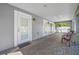Spacious outdoor patio with brick flooring, a screened enclosure and multiple doorways at 3709 W Dale Ave, Tampa, FL 33609
