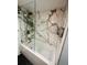 Stylish bathtub with marble tile surround and glass enclosure, ideal for a relaxing soak at 4237 Brentwood Park Cir, Tampa, FL 33624