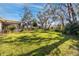 Expansive backyard featuring well-manicured lawn, trees, and a view of the house at 4614 Sandpointe Dr, New Port Richey, FL 34655