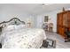 Comfortable bedroom featuring wood-look floors, a metal bed frame and a vintage wood cabinet at 4614 Sandpointe Dr, New Port Richey, FL 34655