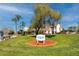 Inviting view of the Heritage Lake Clubhouse framed by lush landscaping and palm trees at 4614 Sandpointe Dr, New Port Richey, FL 34655