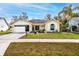 Charming home featuring an attached garage and covered entry way with a manicured lawn and landscaped garden at 4614 Sandpointe Dr, New Port Richey, FL 34655
