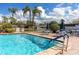 Sparkling pool with poolside seating, lush landscaping, and tranquil fountain views at 4614 Sandpointe Dr, New Port Richey, FL 34655