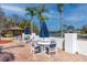 Relaxing poolside seating area with tables, chairs, umbrellas, and a serene lake view at 4614 Sandpointe Dr, New Port Richey, FL 34655