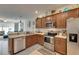 Open kitchen offers stainless appliances, wooden cabinets, and adjacent living and dining areas at 5312 Sylvester Loop, Tampa, FL 33610