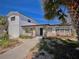 Charming home with a mix of white wood and stone facade, complemented by lush landscaping at 590 Baywood N Dr, Dunedin, FL 34698