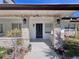 A welcoming front porch featuring stone pillars, stylish light fixtures, and a dark wood door at 590 Baywood N Dr, Dunedin, FL 34698
