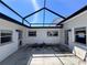 Enclosed patio with white walls, multiple access doors, and a screened ceiling at 590 Baywood N Dr, Dunedin, FL 34698