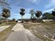 Single Gathering home featuring mature palm trees, driveway, and detached garage at 6042 Countryman Ln, New Port Richey, FL 34652