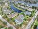 Aerial view of a waterfront neighborhood showcasing a blue home with lush landscaping and canal access at 613 Manns Harbor Dr, Apollo Beach, FL 33572