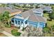 Bright blue home featuring a well-manicured lawn, three-car garage, and a welcoming front porch at 613 Manns Harbor Dr, Apollo Beach, FL 33572