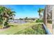 Tranquil backyard with green grass, access to the canal, and a glimpse of neighboring homes at 613 Manns Harbor Dr, Apollo Beach, FL 33572
