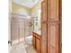 Well-lit bathroom with a large shower, toilet, sink, and a storage cabinet at 613 Manns Harbor Dr, Apollo Beach, FL 33572