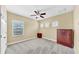 This bedroom features neutral carpet, three windows, ceiling fan and dark wood furniture at 613 Manns Harbor Dr, Apollo Beach, FL 33572