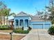 Charming blue home featuring a three-car garage and beautifully landscaped front yard at 613 Manns Harbor Dr, Apollo Beach, FL 33572