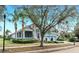 Beautiful blue home with a well-manicured lawn, mature trees, and inviting curb appeal at 613 Manns Harbor Dr, Apollo Beach, FL 33572