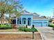 Charming two-story home with a well-manicured lawn, a welcoming front porch, and a three car garage at 613 Manns Harbor Dr, Apollo Beach, FL 33572