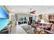 Spacious living room with a large TV, comfortable leather sofa, and a view to the screened-in lanai at 613 Manns Harbor Dr, Apollo Beach, FL 33572