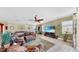 Cozy living room featuring a leather sofa, ceiling fan, and a view of the dining area at 613 Manns Harbor Dr, Apollo Beach, FL 33572