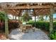 Secluded picnic area with a wooden table, seating, and surrounding tropical plants at 613 Manns Harbor Dr, Apollo Beach, FL 33572